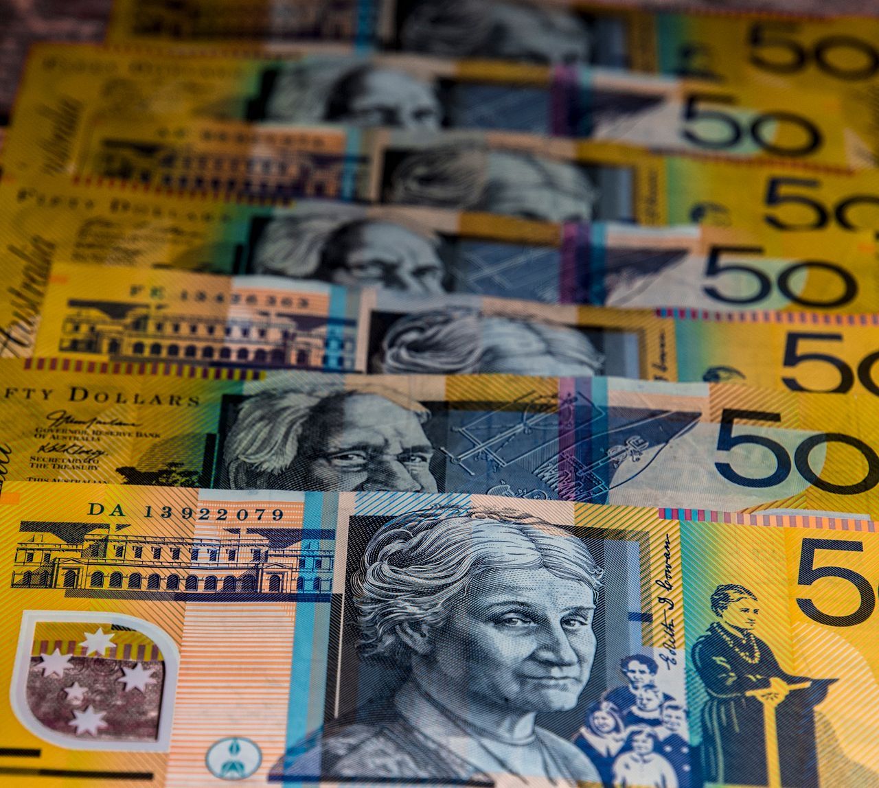 Close-up view of Australian 0 bills arranged in a pattern. Vibrant colors and detailed imagery highlight currency features.